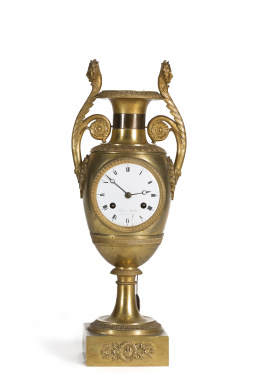 1312.  Reloj de sobremesa Imperio, en bronce dorado en forma de ánfora. Francia, primer tercio del S. XIX.