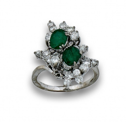 110.  Sortija con dos esmeraldas ovales y brillantes en garras a diferentes alturas,en oro blanco de 18K.