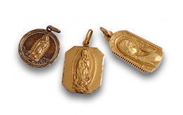 756.  Lote de tres medallas colgantes,dos de ellas de Virgen de Guadalupe, en oro de 18K.