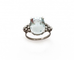 107.  Sortija con aguamarina de talla oval flanqueada por triángulos escalonados de brillantes en montura de platino.