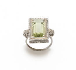 138.  Sortija con berilo verde pálido de talla rectangular,orlado de diamantes.