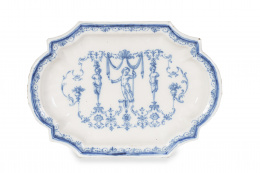 1155.  Fuente de cerámica esmalta en azul con puntilla Berain, con un “putto” y esfinges a los lados.Alcora, 1727-1749.