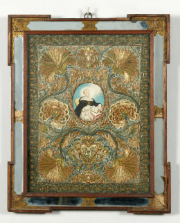 534.  Bordado con hilos dorados y de color de profusa decoración con claveles, ramas, granadas y un corazón, enmarcan a Santo Tomás, pintado sobre papel. Marco en madera, espejo y papel grabado y dorado.Trabajo Mejicano, S. XVIII.