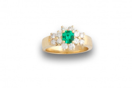 743.  Sortija con rosetón de esmeralada y brillantes entre parejas de brillantes. En oro de 18K.