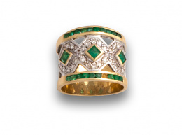 76.  Sortija ancha de oro amarillo con esmeraldas y brillantes dibujando rombos entre líneas de esmeraldas redondas engastadas en carril.