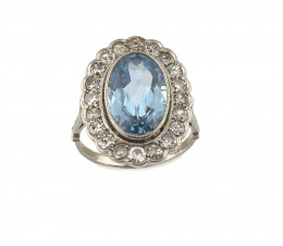 683.  Sortija de pp. S.XX con topacio azul de talla oval orlado de btes de talla antigua en montura de platino