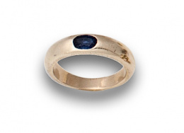 668.  Sortija alianza con zafiro oval en oro de 18K.