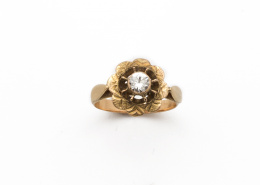 602.  Sortija flor de pp s. XX con símil diamante central, en oro de 18K.