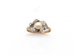 614.  Sortija con perla cultivada entre bandas oblicuas de zafiros blancos.