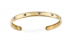 262.  Pulsera rígida de media caña con cinco zafiros talla corazón y triángulo,engastados en el aro de oro liso amarillo de 18K.