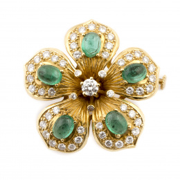 149.  Broche flor con esmeraldas cabuchón rodeadas de brillantes en cinco pétalos que rodean rosetón central de brillantes