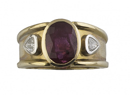 527.  Sortija ancha con rubí de talla oval de 2,70 ct flanqueado por dos diamantes de talla triangular