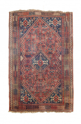 924.  Alfombra en lana con campo rojo y cartela geométrica central.Persia..