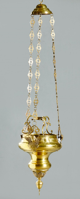 1187.  Lámpara votiva de bronce, con cabezas de querubines aplicados.Trabajo español, S. XIX.