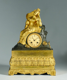 455.  Reloj de bronce dorado y patinado con figura de dama en el plinto.Francia, h. 1830-1840