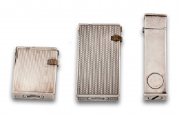 713.  Lote tres encendedores Dunhill c.1920 ,con decoración de estrias ,estrias onduladas y marchamo decomiso .De gasolina