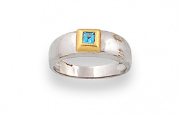 633.  Sortija con topacio cuadrado azul en montura de oro bicolor de 18K.