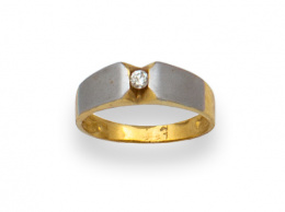 78.  Sortija con brillante engastado en carril en montura de oro bicolor de 18K.