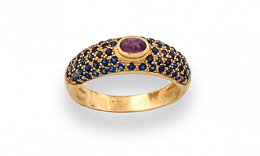 109.  Sortija con pavé de zafiros y cabuchón de rubí central, en oro de 18K.