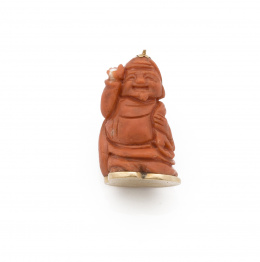 690.  Figura de buda en coral rojo con base en oro de 18K.