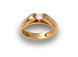 59.  Sortija con circonita central engastada carril y oro amarillo de 18K.