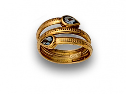 121.  Sortija serpenteada con dos topacios perilla azules en oro amarillo de 18K.