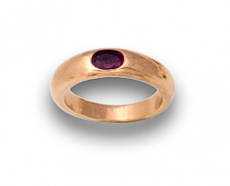 666.  Sortija alianza con rubí oval en oro amarillo de 18K.