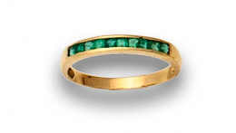 86.  Anillo de esmeraldas carré engastadas en carril en montura de oro de 18K.