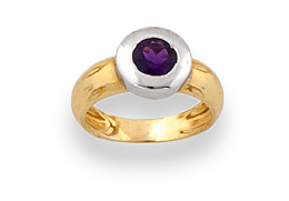 634.  Sortija con amatista circular , en marco de oro blanco sobre aro de oro amarillo de 18K.