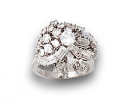 675.  Sortija de brillantes y diamantes talla baguette engastados en garras que componen montura elevada.