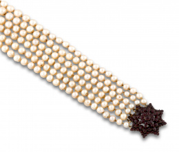 595.  Collar de pps s XX con seis hilos de perlas cultivadas de tamaño creciente ,y con cierre en forma de estrella de granates.
