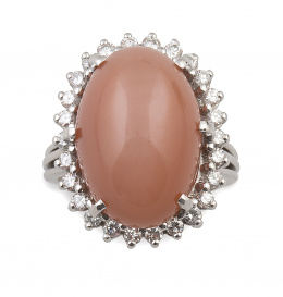 313.  Sortija con gran cabuchón de piedra luna anaranjada orlada de brillantes que suman 0,60 ct aprox 