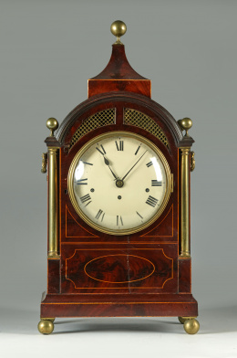 714.  Reloj de sobremesa de madera de palma de caoba, fileteado de limoncillo y columnillas de latón aplicadoInglaterra, h. 1830 - 40.