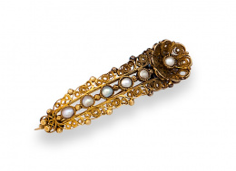 564.  Broche de pp.s.XIX en forma de banda arqueada con flor en el extremo ,de filigrana con perlitas finas .