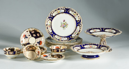 519.  Parte de dos servicios en loza pintada, dorada y esmaltada en azul, ambas decoradas con flores; las tazas inglesas h. 1820 y los platos y salvillas de mediados del S. XIXS.XIX.