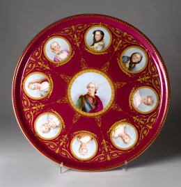 1130.  Plato de porcelana esmaltada en granate con retratos de Luis XV en el asiento.Francia segunda mitad S. XIX.