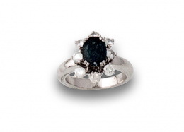 616.  Sortija con zafiro orlado de brillantes en oro blanco de 18K.