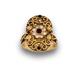 116.  Sortija oriental de frente oval con flor central de brillantes y rubí, rodeada por adornos de filigrana de cordoncillo, y rubíes y zafiros en chatón.