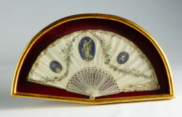 999.  Abanico neoclásico con país de papel pintado decorado con medallones en grisalla, haciendo referencia al Amor y guirnaldas de flores; varillaje con decoración calada y varillaje tallado en marfil.Trabajo francés, h. 1790-800..
