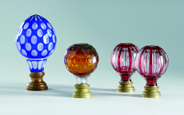 1031.  Pareja de remates de cristal doblado con forma de bola en rojo y cristal traslúcido, S. XX..