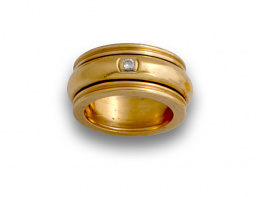 728.  Sortija ancha con aro central móvil de brillantes en oro de 19K.