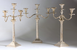 1192.  Tres candelabros - candeleros  victorianos  de estilo Jorge III, de tres brazos de luz, en metal plateado. Marcados en la base.Trabajo inglés, Goldsmith Cº Newcastle, pp. S . XX.