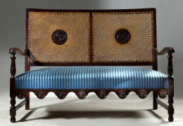 565.  Sofá de estilo inglés de madera tallada, con respaldo cané.pp. del S. XX..