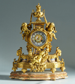 1105.  Watherhouse & Cº. Her Majesty JewellersReloj de sobre mesa de estilo Luis XVI de bronce con “putti” y porcelana esmaltada.Francia, segunda mitad del S. XIX