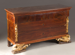 1074.  Cómoda fernandina en madera de caoba. Decoración en madera tallada, estucada y dorada.Trabajo español, h. 1820