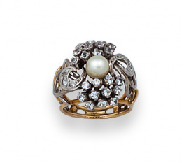 35.  Sortija años 50 con perla central y zafiros blancos entre líneas de oro y platino.