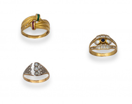 96.  Conjunto de tres anillos el oro de 18K.:nudo oro con esmeraldas y rubíes, circonitas y zafiro en trabajo calado aro de oro y ramas de strass