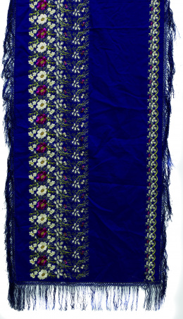 1058.  Mantoncillo con flores de color bordadas sobre seda azul.