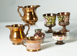 513.  Dos copas con flores de color, un jarrito, una copita con cenefa de flores y una taza con franja en rosa en relieve y oro, un cántaro, una jarrita con decoración en relieve.Bristol, S. XIX.