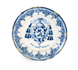 411.  Plato de cerámica esmaltada en azul de cobalto, con escudo cardenalicio de los jerónimos y puntilla berain.Talavera, S. XVIII..